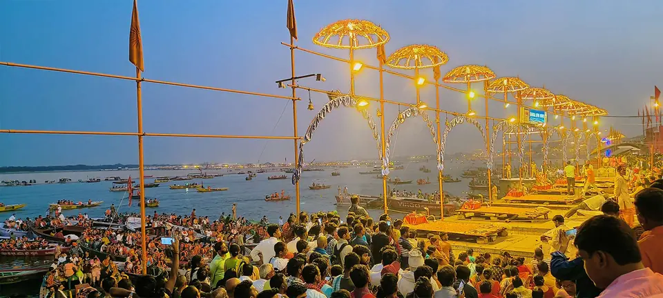 Evening Ganga aarti on the ghats of Varanasi with lit canopies and crowds by the river