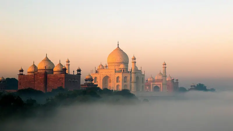 The Taj Mahal and its mosque rising above morning mist on the Yamuna