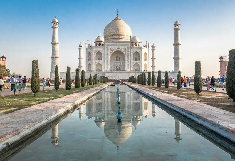 The Taj Mahal reflected in the central pool, lined with cypress trees