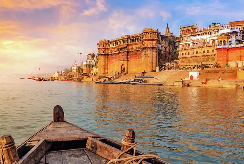 Wooden boat on the Ganges facing the ghats of Varanasi at sunrise
