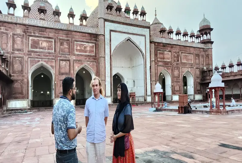 Guide with visitors in the courtyard of Jama Masjid, Agra