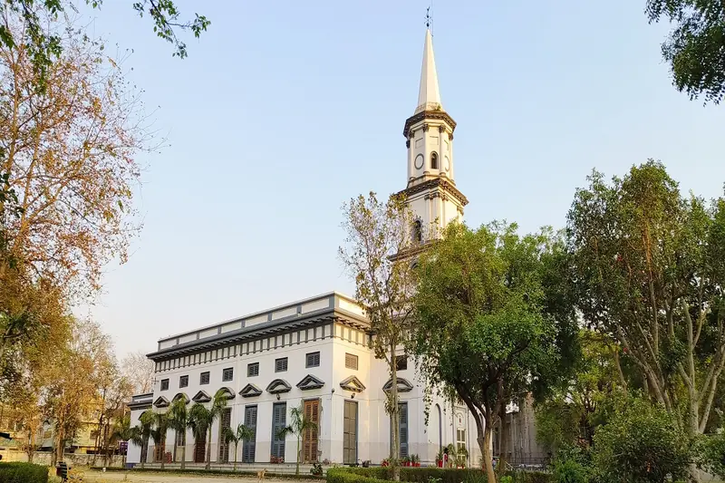Colonial-era building and bell tower among trees in Agra