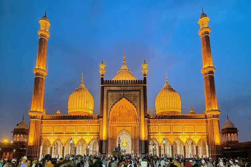 Mosque with gilded domes and minarets lit up at night